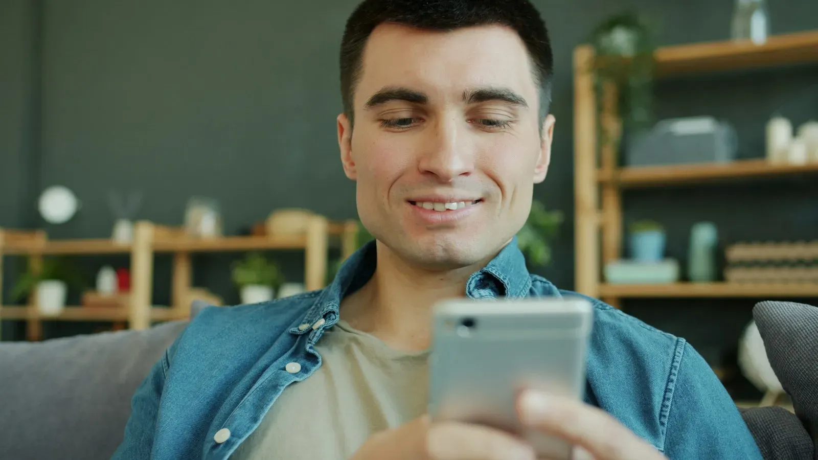 Mann lächelt beim Chatten auf seinem Smartphone – die beste Grindr-Alternative