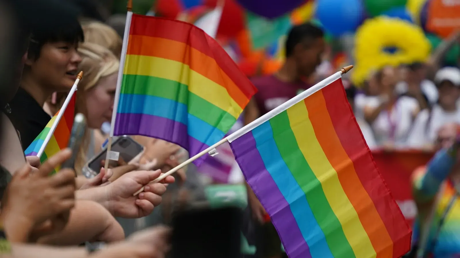 Regenbogenflaggen auf einer Pride-Parade – Coming-out als Erwachsener