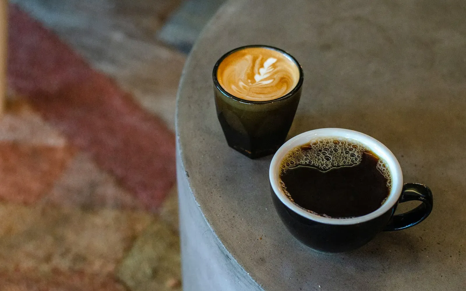 Zwei Kaffeetassen auf einem runden Tisch in einem Café