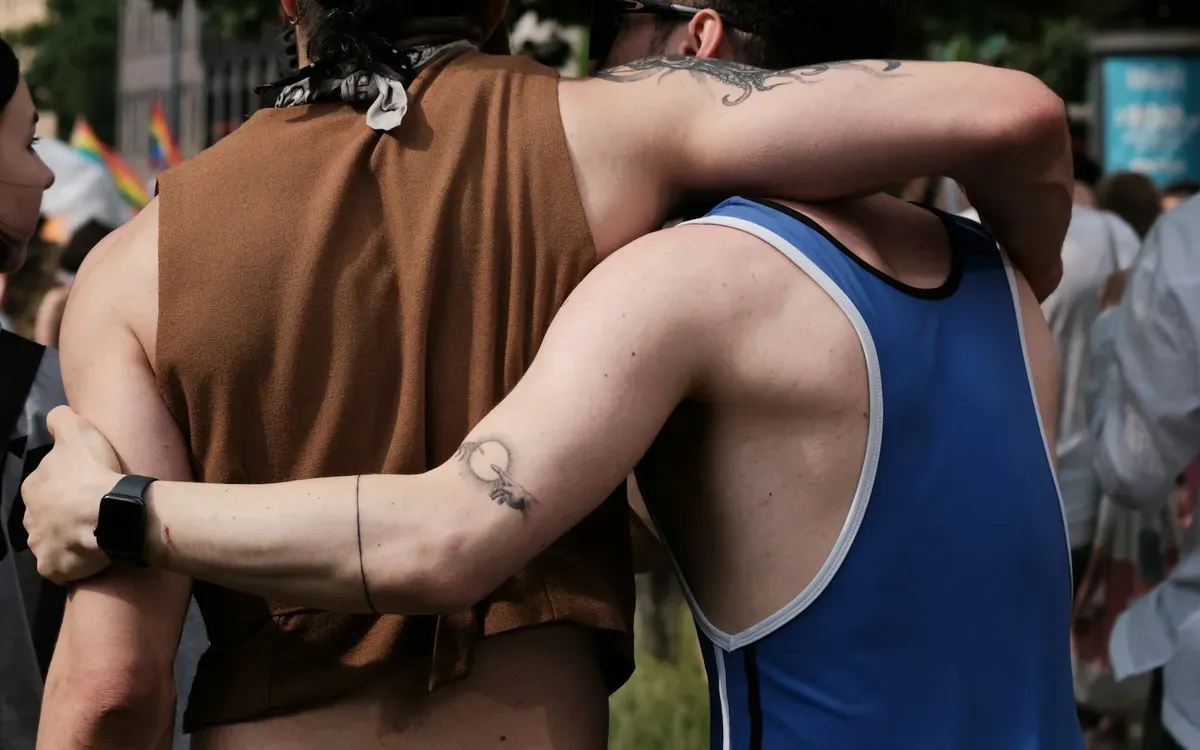 Zwei Männer Arm in Arm auf einer Pride-Veranstaltung